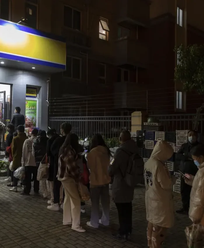 Gran cantidad de personas con mascarillas para protegerse del coronavirus hacen fila en un supermercado, el domingo 27 de marzo de 2022, en Shanghái, China. (AP Foto)